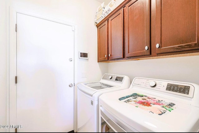 clothes washing area featuring cabinets and washing machine and dryer