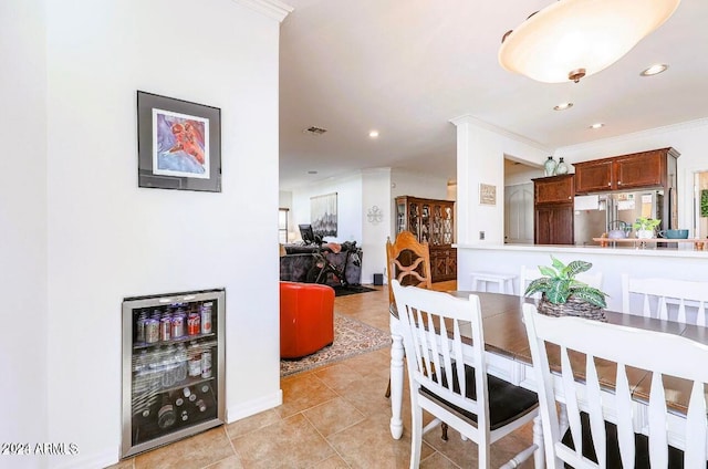 dining area with wine cooler, crown molding, and light tile patterned floors