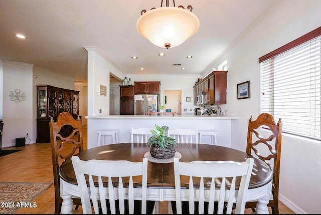 tiled dining room featuring crown molding