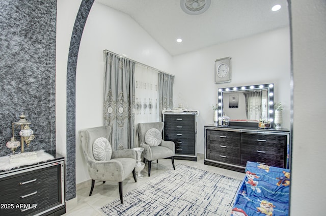 sitting room featuring light tile patterned floors and high vaulted ceiling