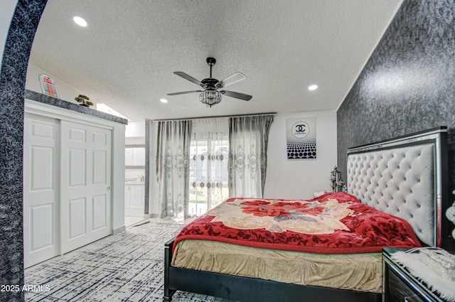 bedroom with vaulted ceiling, ceiling fan, and a textured ceiling