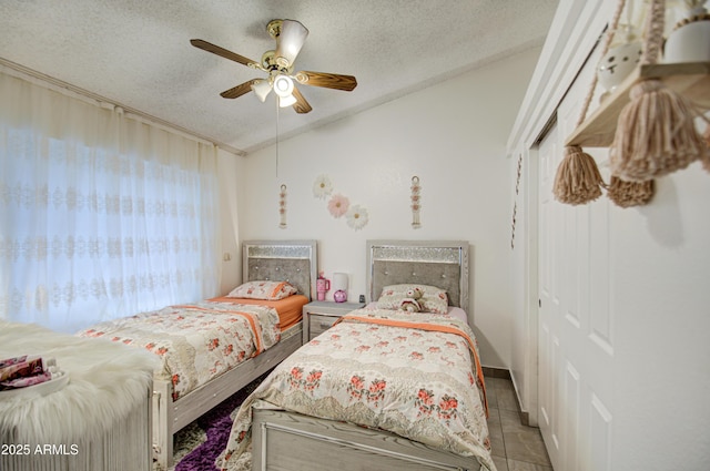 bedroom featuring a textured ceiling, ceiling fan, light tile patterned floors, and multiple windows