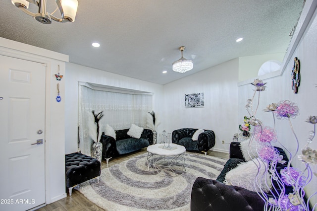 living room with an inviting chandelier, a textured ceiling, and hardwood / wood-style floors