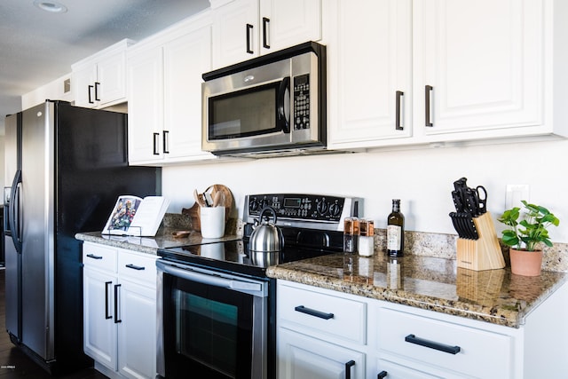 kitchen featuring stainless steel microwave, black fridge with ice dispenser, white cabinets, and electric stove