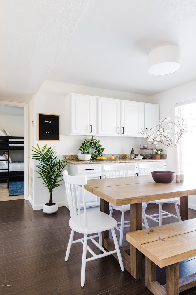 kitchen with dark wood-type flooring, white cabinets, and light countertops