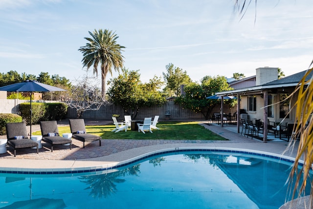 view of pool with a fenced in pool, a patio, a lawn, and a fenced backyard
