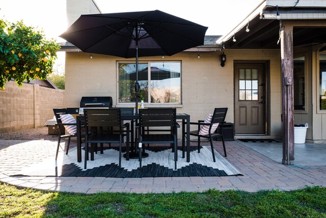 view of patio with outdoor dining space, a grill, and fence