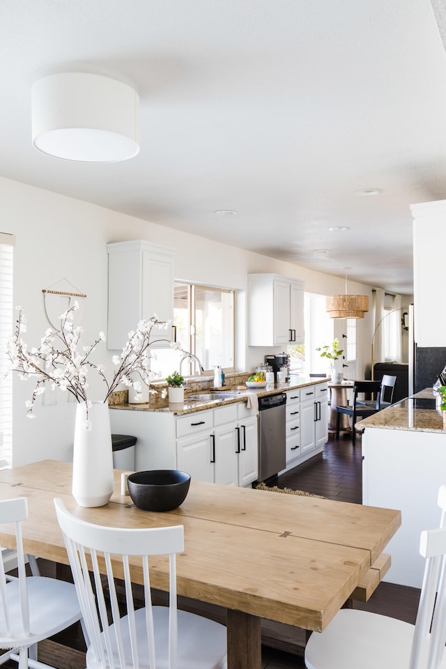 kitchen featuring a wealth of natural light, white cabinets, dishwasher, and dark wood-style flooring