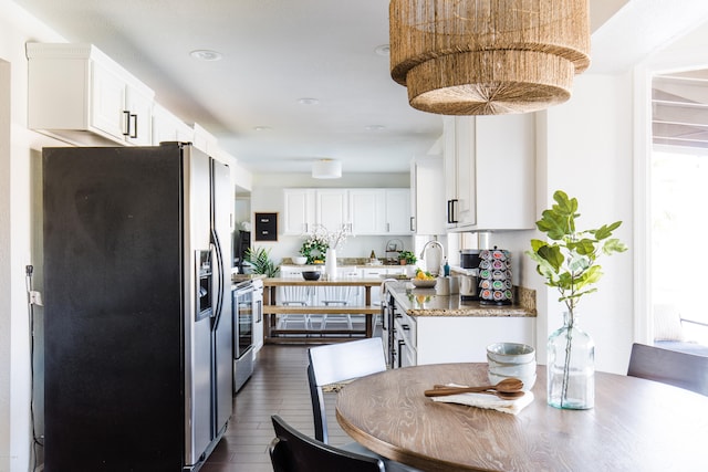 kitchen featuring stainless steel electric range oven, white cabinetry, dark wood-type flooring, and fridge with ice dispenser