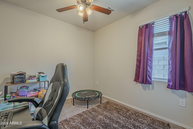 carpeted office space featuring ceiling fan