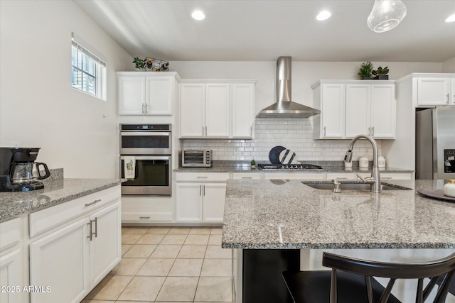 732 W Flintlock Way, Chandler, AZ 85286 - kitchen with wall chimney range hood, a sink, appliances with stainless steel finishes, a breakfast bar area, and white cabinetry