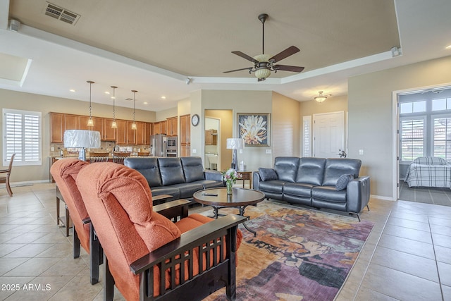 4497 E Ficus Way, Gilbert, AZ 85298 - living room with light tile patterned floors, a raised ceiling, ceiling fan, and baseboards