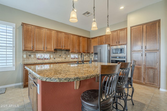 4497 E Ficus Way, Gilbert, AZ 85298 - kitchen with decorative backsplash, visible vents, brown cabinets, a breakfast bar, and stainless steel appliances