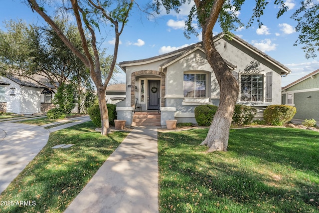 view of front of house featuring stucco siding, a tiled roof, and a front yard