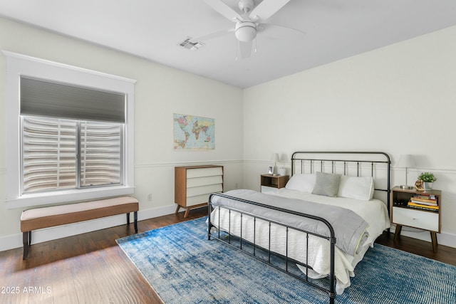 bedroom featuring baseboards, visible vents, ceiling fan, and wood finished floors