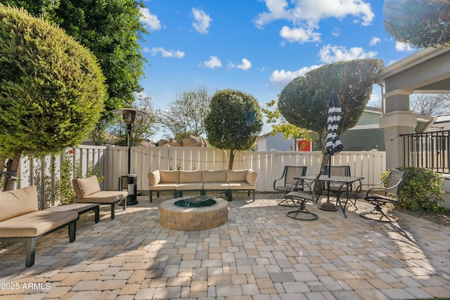 view of patio with a fenced backyard and an outdoor living space with a fire pit