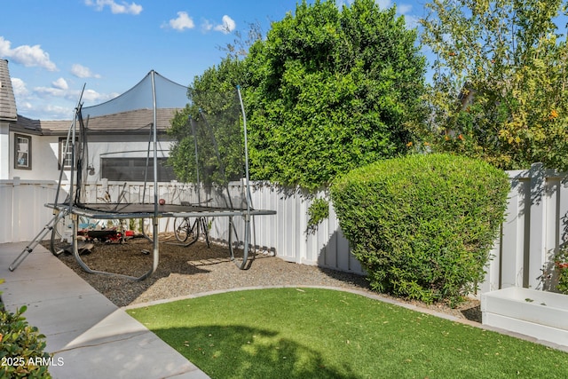 view of yard with a trampoline and a fenced backyard