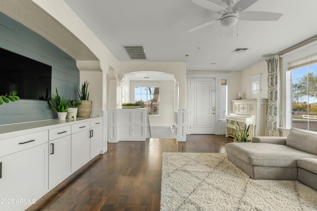 living area featuring dark wood-type flooring, visible vents, and a healthy amount of sunlight