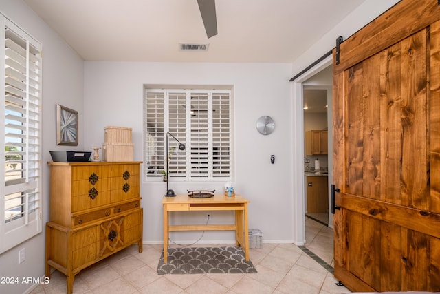 19892 N Shadow Mountain Dr, Surprise, AZ 85374 - interior space featuring a barn door, a ceiling fan, baseboards, light tile patterned floors, and visible vents
