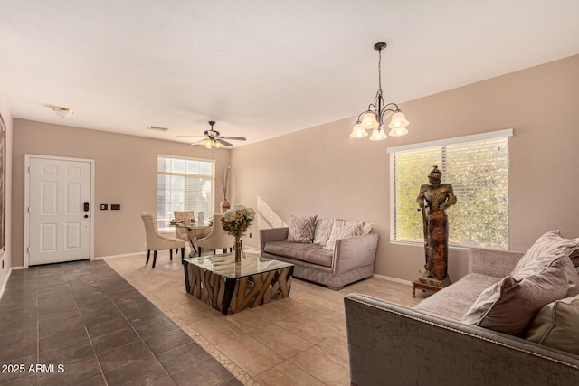 living room featuring ceiling fan with notable chandelier and tile patterned floors