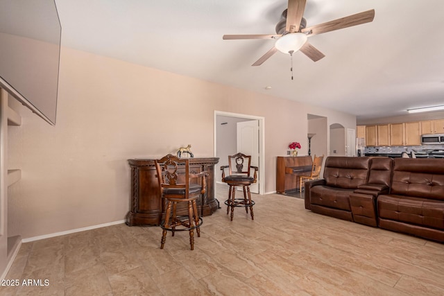 living room with ceiling fan and bar area