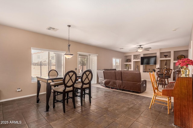 dining area featuring ceiling fan and built in shelves