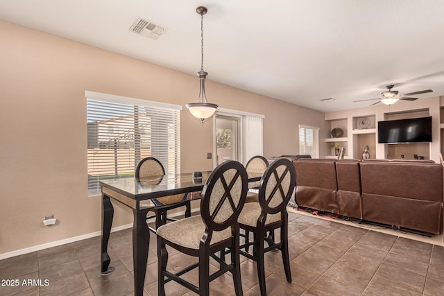 dining room with ceiling fan and built in features