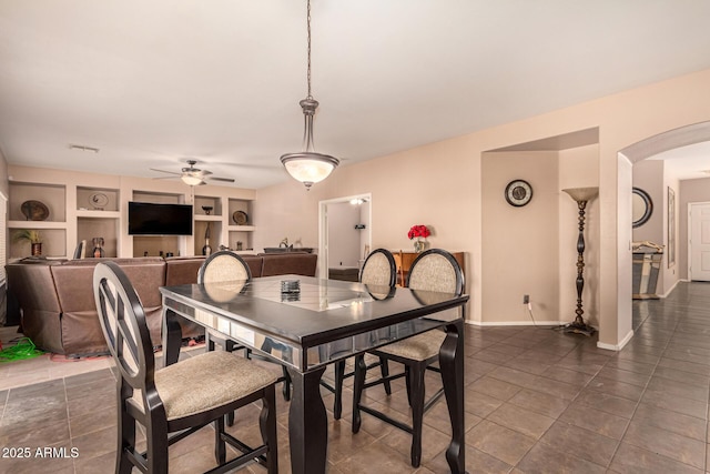 tiled dining area with built in shelves and ceiling fan