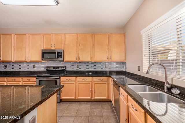 kitchen featuring light tile patterned flooring, sink, dark stone countertops, stainless steel appliances, and light brown cabinets