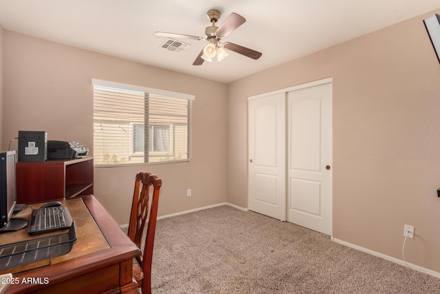 carpeted office space featuring ceiling fan