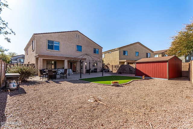 back of property with a storage shed, a gazebo, and a patio