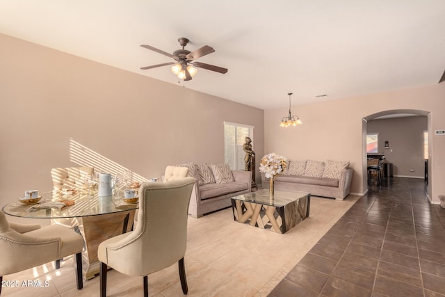 living room featuring ceiling fan with notable chandelier and tile patterned floors