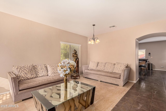 living room with an inviting chandelier, plenty of natural light, and tile patterned floors