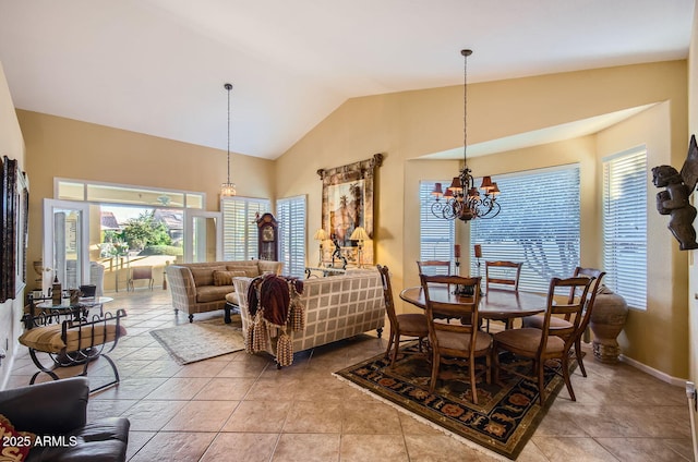 dining space with lofted ceiling, an inviting chandelier, baseboards, and light tile patterned flooring