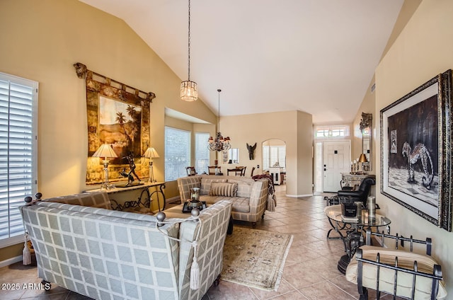 living area with high vaulted ceiling, tile patterned floors, and baseboards