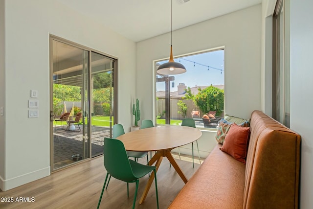 dining area featuring light wood-style floors, plenty of natural light, and baseboards