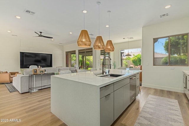 kitchen featuring a sink, a center island with sink, healthy amount of natural light, light wood-type flooring, and recessed lighting
