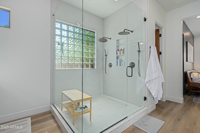 full bathroom featuring baseboards, wood finished floors, and a shower stall
