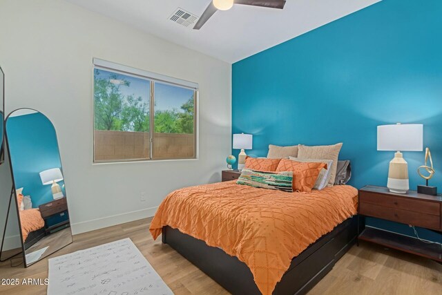 bedroom with baseboards, wood finished floors, and ceiling fan