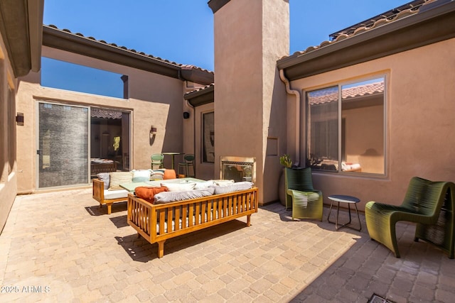 view of patio with an outdoor living space with a fireplace