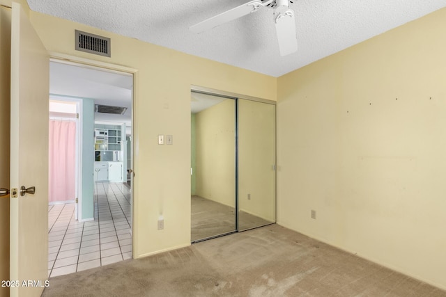 4062 W Mescal St, Phoenix, AZ 85029 - unfurnished bedroom featuring a closet, carpet, tile patterned floors, a textured ceiling, and ceiling fan