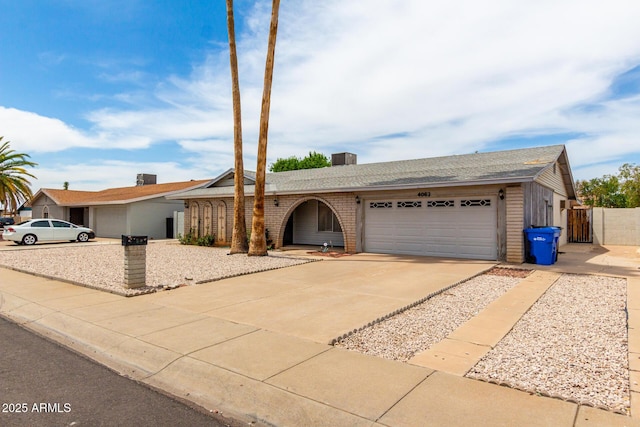 4062 W Mescal St, Phoenix, AZ 85029 - ranch-style house with an attached garage, driveway, brick siding, and roof with shingles