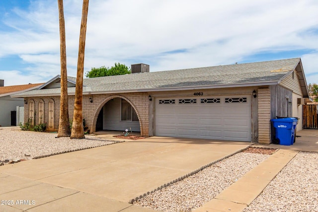 4062 W Mescal St, Phoenix, AZ 85029 - single story home featuring driveway, a garage, roof with shingles, brick siding, and central AC unit