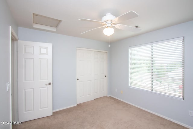 unfurnished bedroom with ceiling fan, a closet, and light carpet