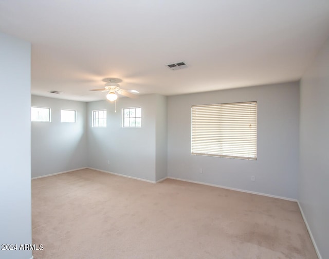 carpeted spare room with ceiling fan