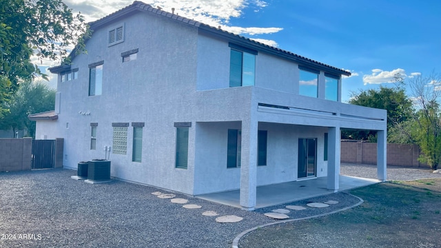 back of property with central air condition unit and a patio