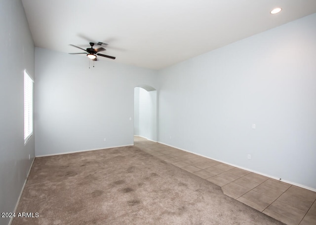 carpeted spare room featuring ceiling fan