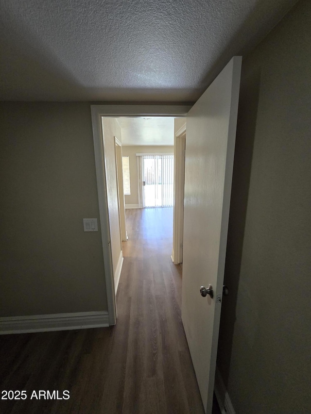 hall with dark hardwood / wood-style floors and a textured ceiling