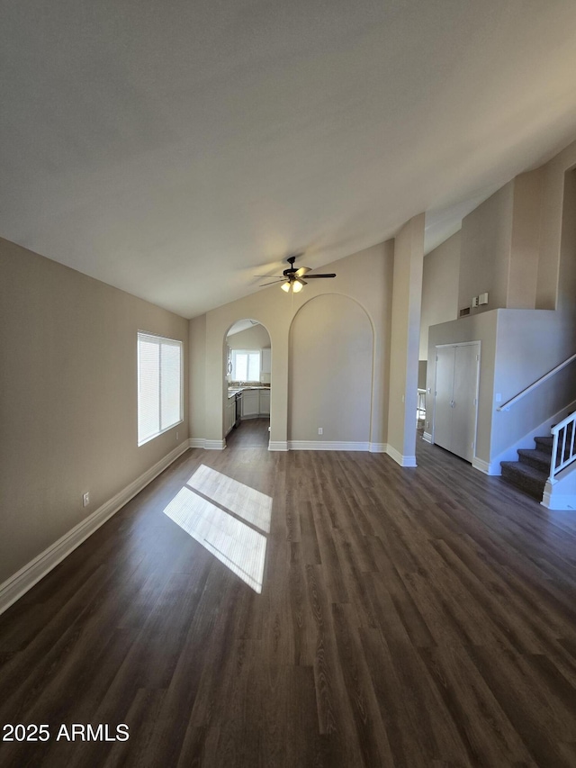 unfurnished living room featuring ceiling fan, lofted ceiling, and dark hardwood / wood-style flooring