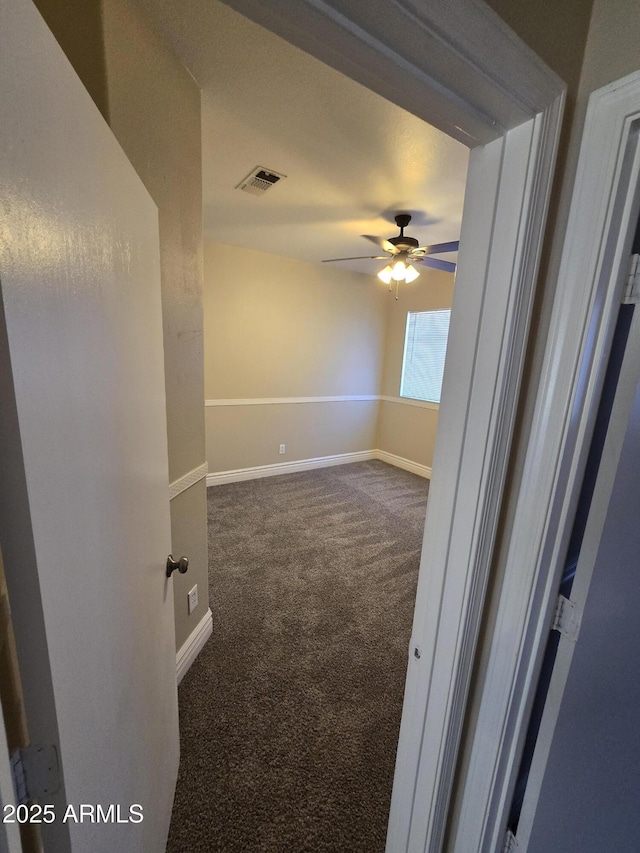 carpeted spare room featuring ceiling fan